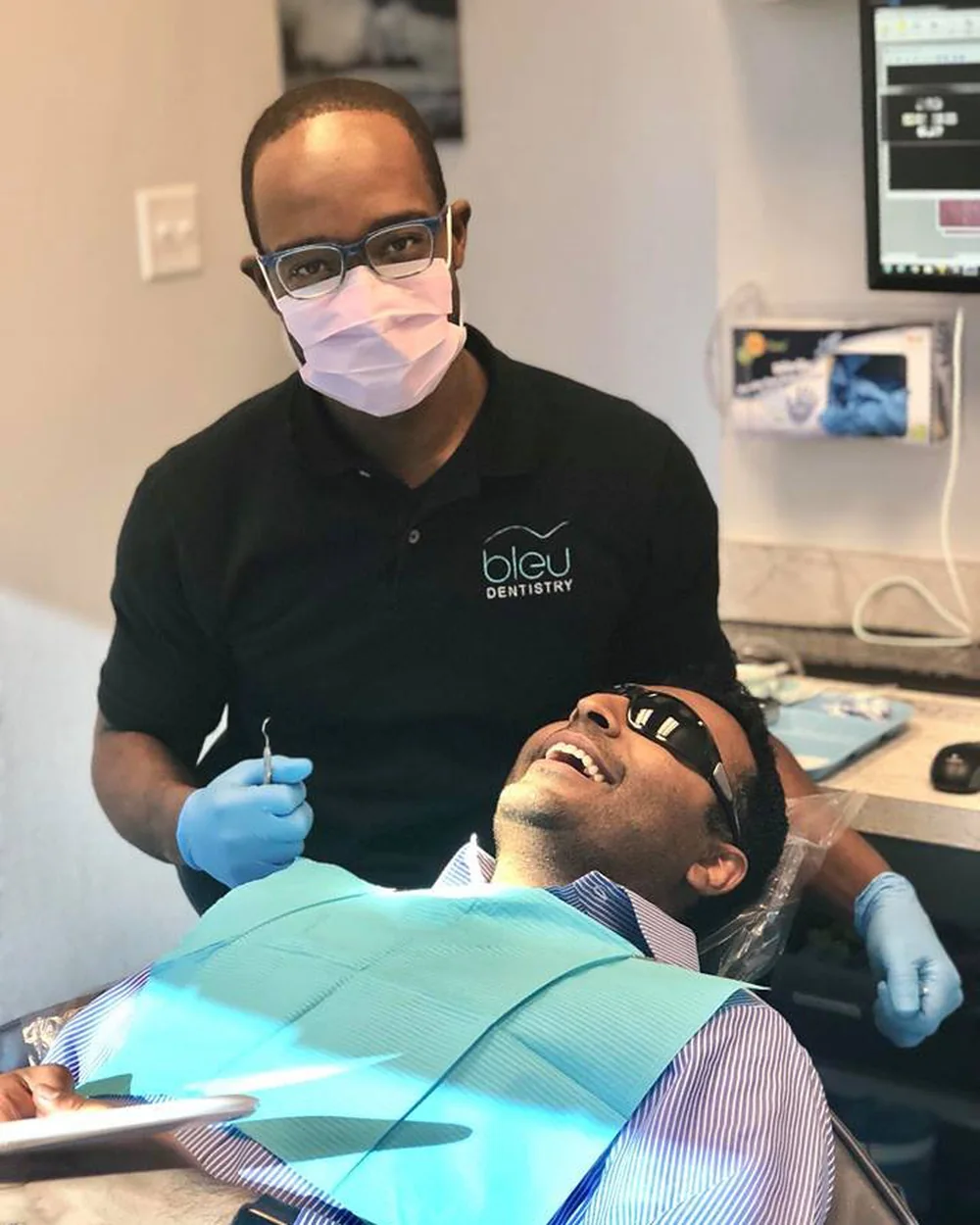 Dr. Allen Charles treating a patient in a Bleu Dentistry treatment room.